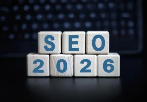 Holzblöcke mit dem Schriftzug "SEO 2026" vor einem verschwommenen Hintergrund, passend für Themen rund um Suchmaschinenoptimierung im Jahr 2026.